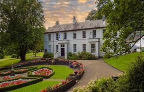 The main house with the circular gardens in the front of the house.